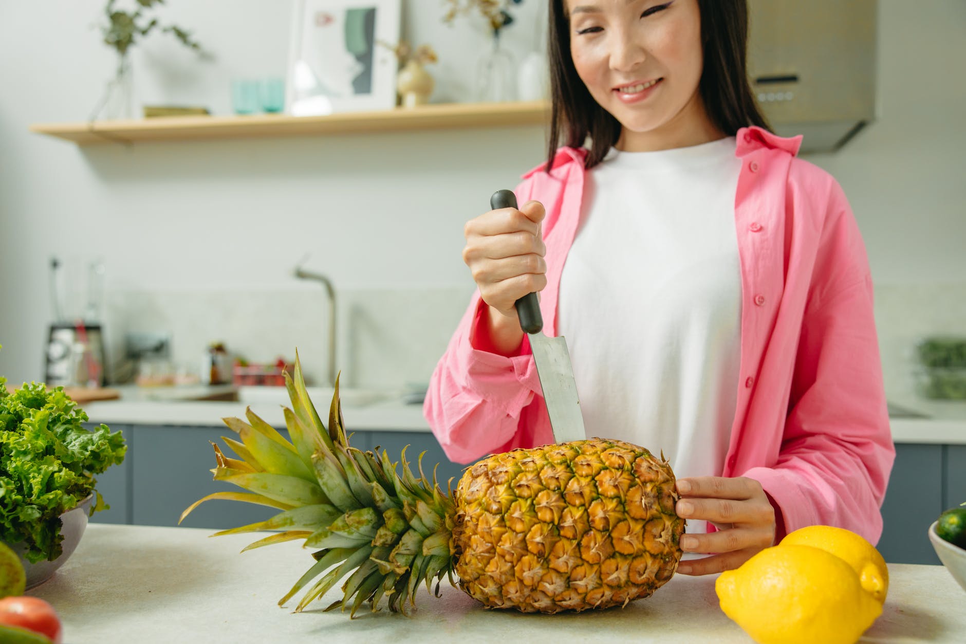 a woman slicing a pineapple